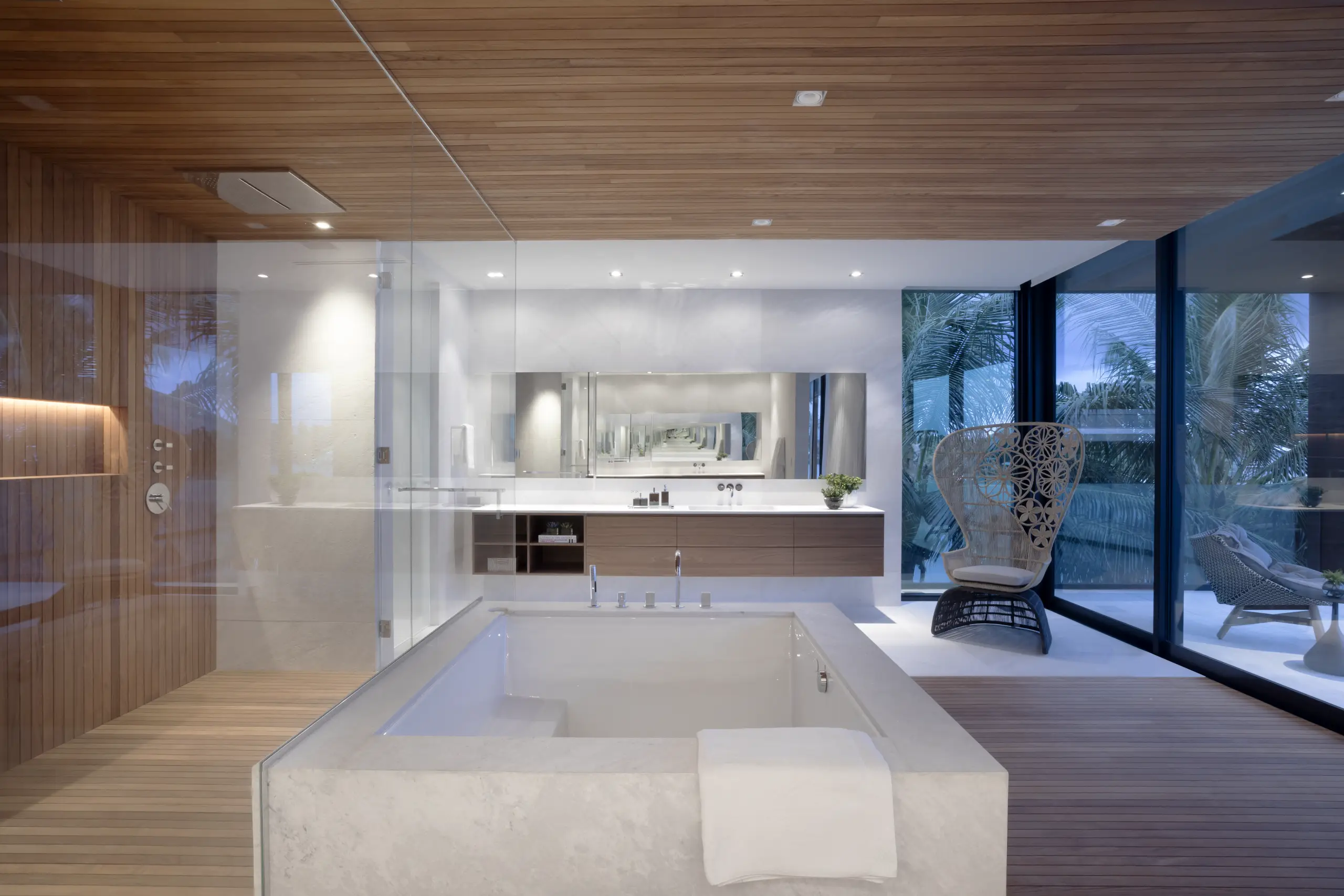 Luxury primary bathroom with spa-style sunken tub, wood accents, and glass walls overlooking Venetian Island in Miami