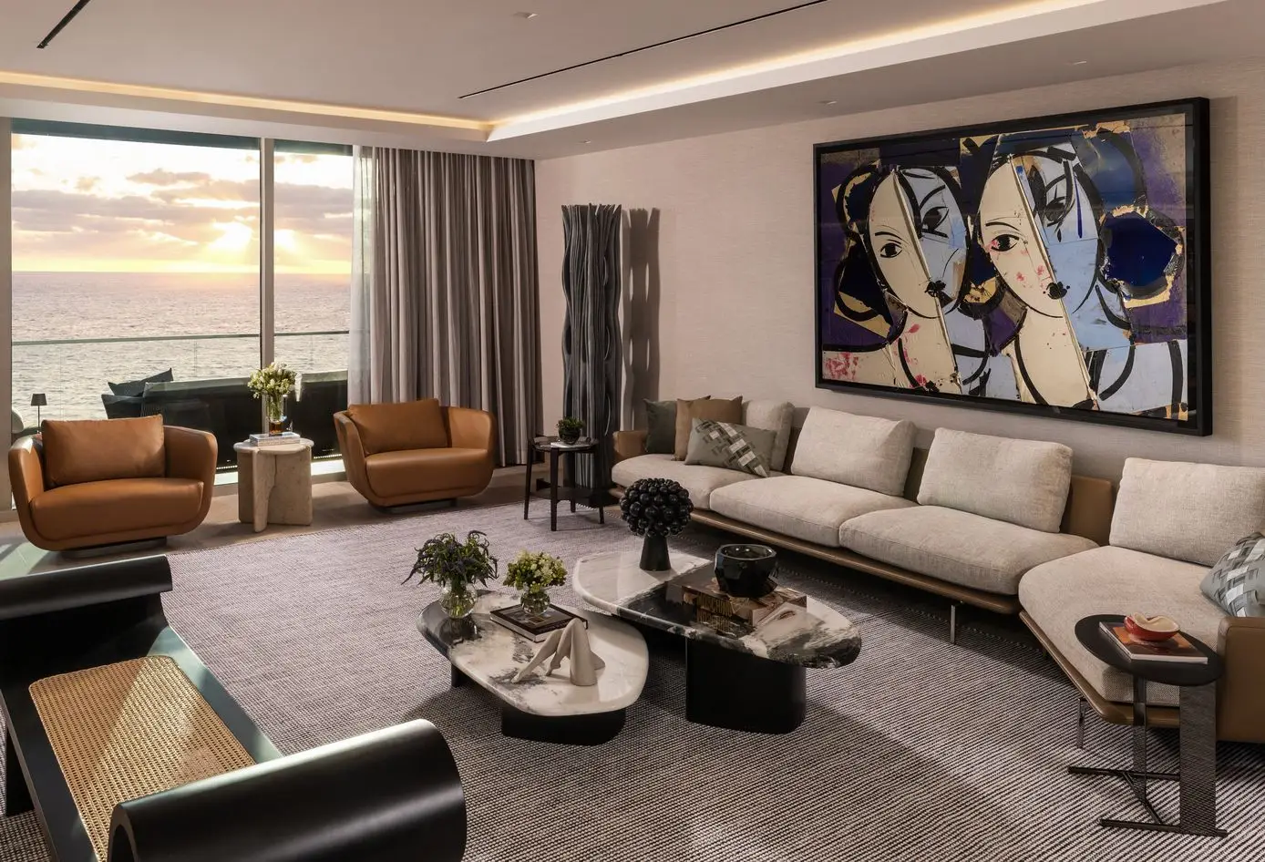 Sophisticated living room at Oceana Bal Harbour with oceanfront sunset views, modern artwork, neutral furnishings, and sculptural decor.