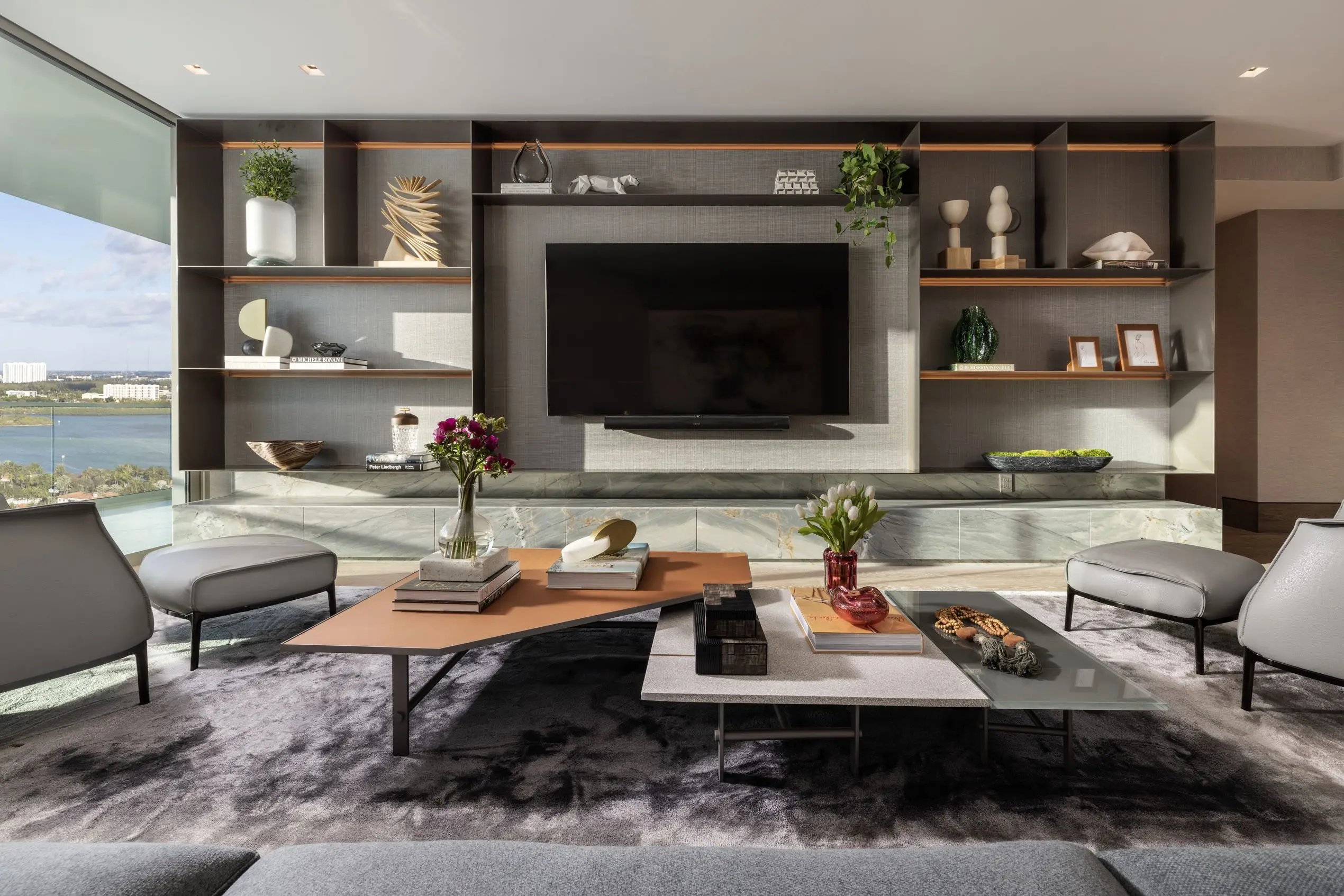 Modern media room at Oceana Bal Harbour with custom built-ins, floating shelves, sculptural decor, and panoramic water views.