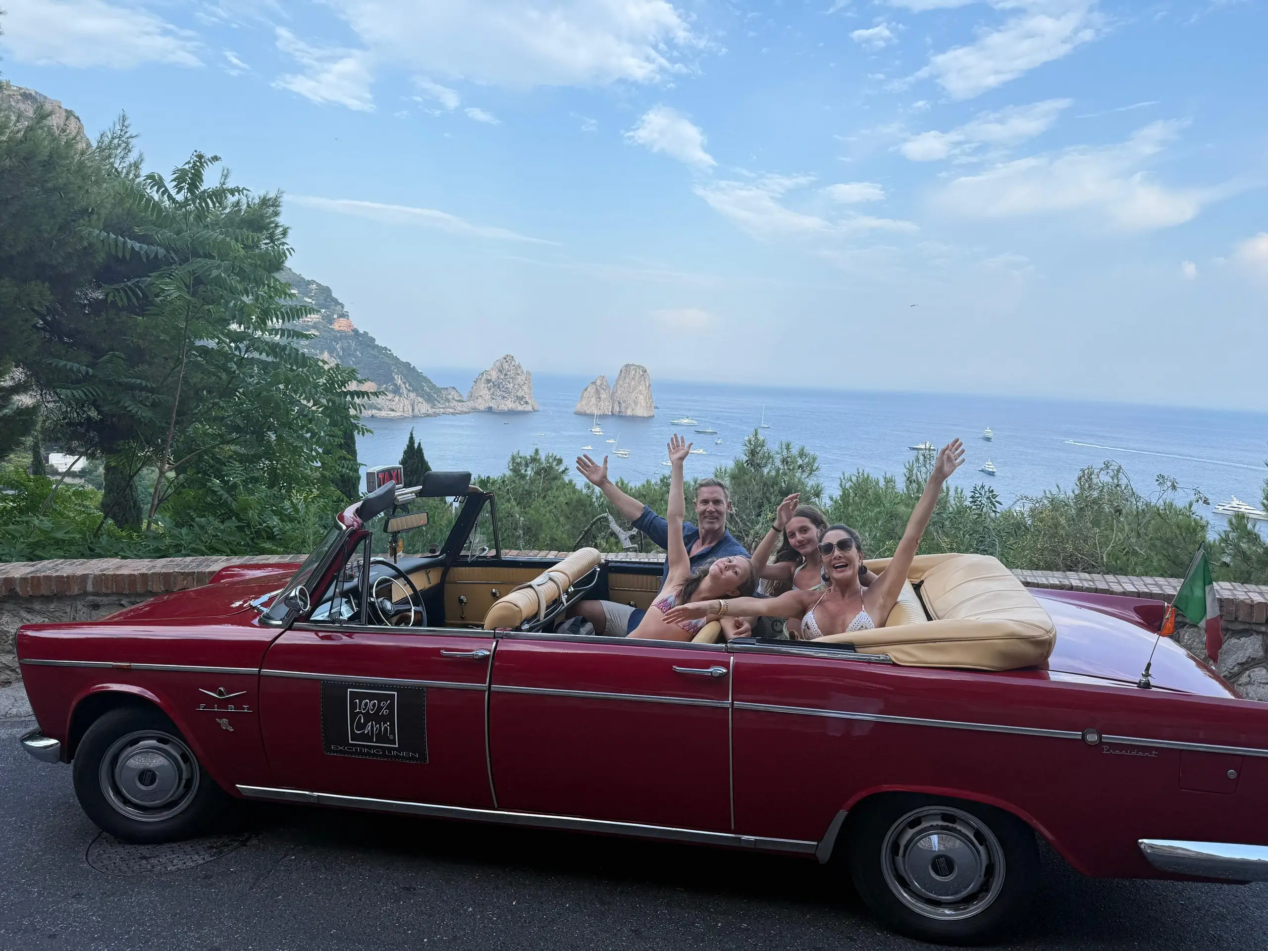 Luciana Fragali and her family enjoying an inspirational trip in a vintage red convertible along the beautiful coast of Capri, Italy.
