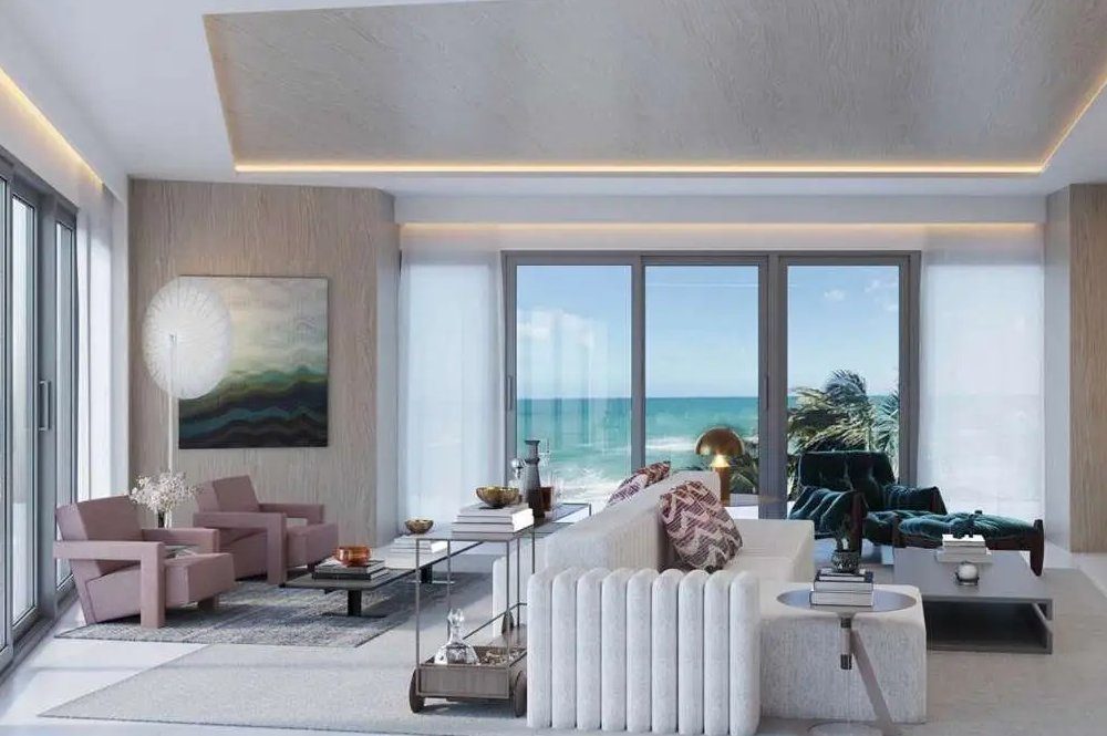 Beachfront living room with floor-to-ceiling windows and direct ocean view