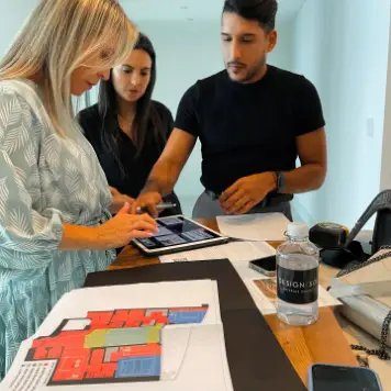 Interior design team reviewing floor plan on a tablet with material samples