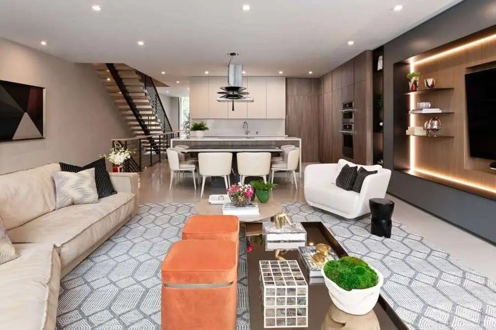 Open-plan living room and kitchen in a modern townhouse with floating staircase