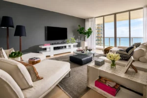 Luxury living room with ocean view, white sofas and gray accent wall