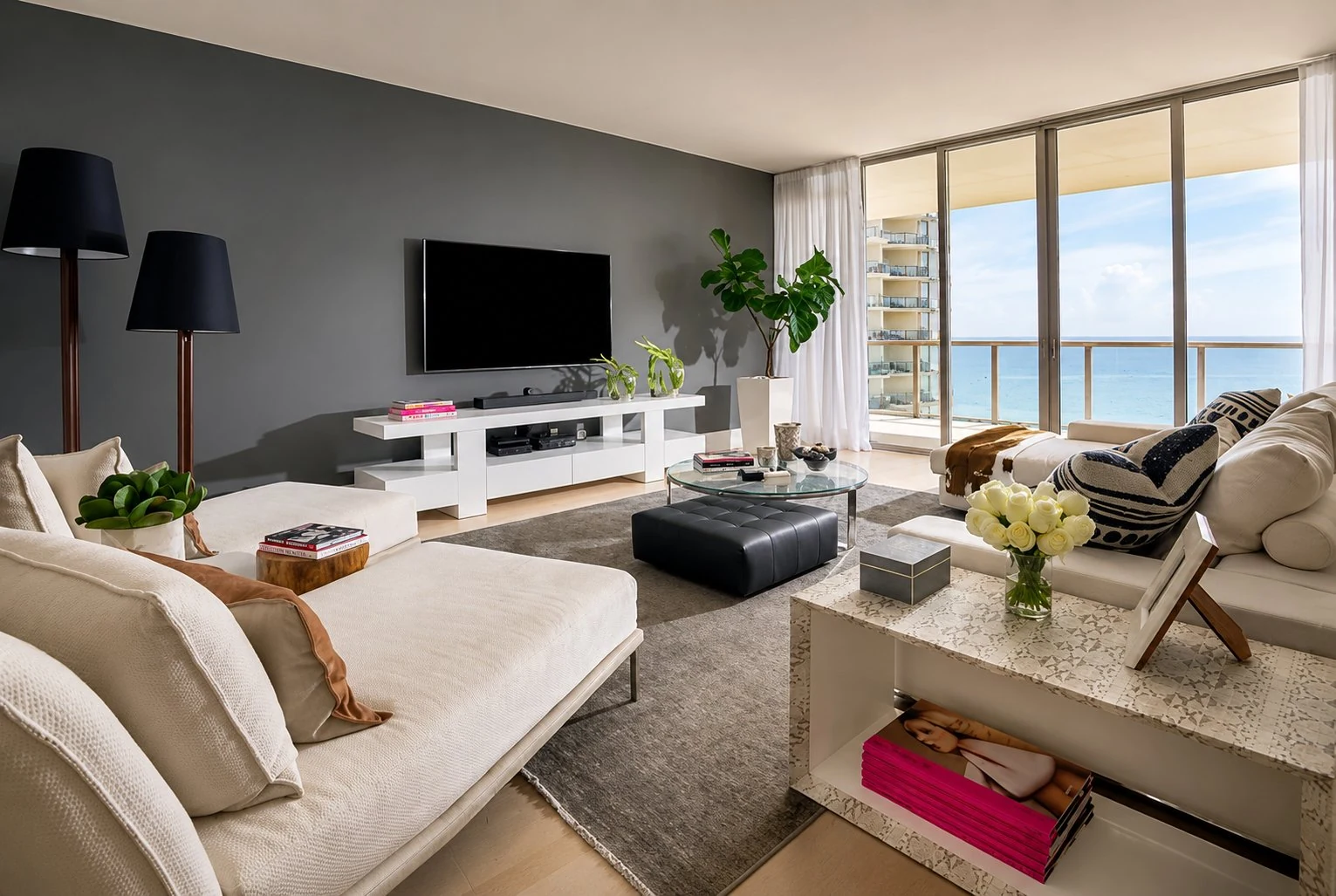 Luxury living room with ocean view, white sofas and gray accent wall