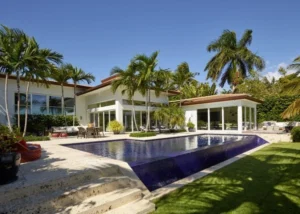 Luxury Miami home exterior with pool, palm trees and open terrace